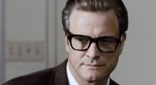 Colin Firth wears horn-rimmed black glasses and his hair slicked back.