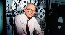 A white man in front of film equipment