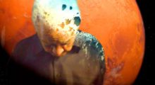 Poet Nikki Giovanni stands with his head bowed. He is superimposed over an image of the planet Mars.