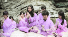 Japanese AUM cult members sit in prayer wearing pink robes.