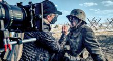 Actor Felix Kammerer as Paul Bäumer in All Quiet on the Western Front. He wears a WWI-era military uniform and has his face painted with soot behind the scenes.