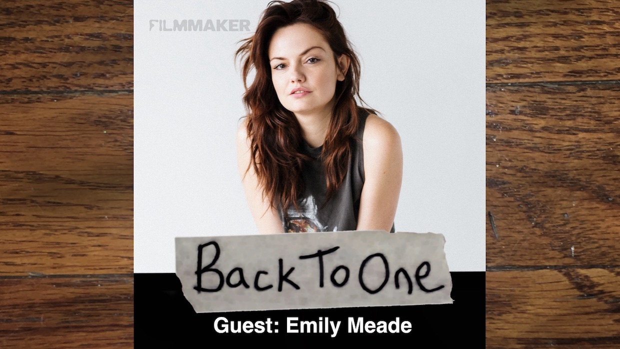 Actress Emily Meade's headshot. She has long, wavy brown hair and wears a gray tank top.