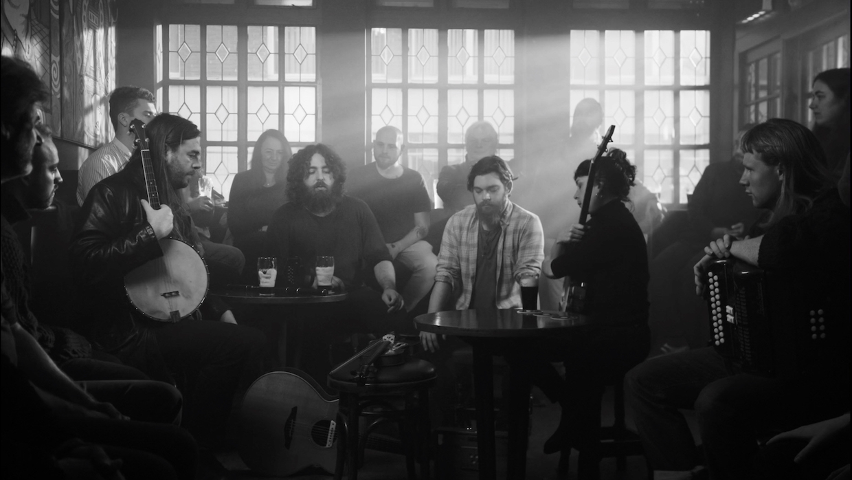 A black and white image of musicians gathered in an Irish pub.