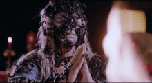 Scorpions cover a person's face and body a they bring their hands together in prayer.