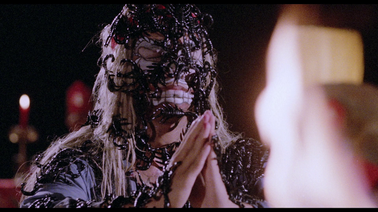 Scorpions cover a person's face and body a they bring their hands together in prayer.