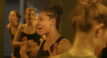 A group of women in fitness clothing are conversing.