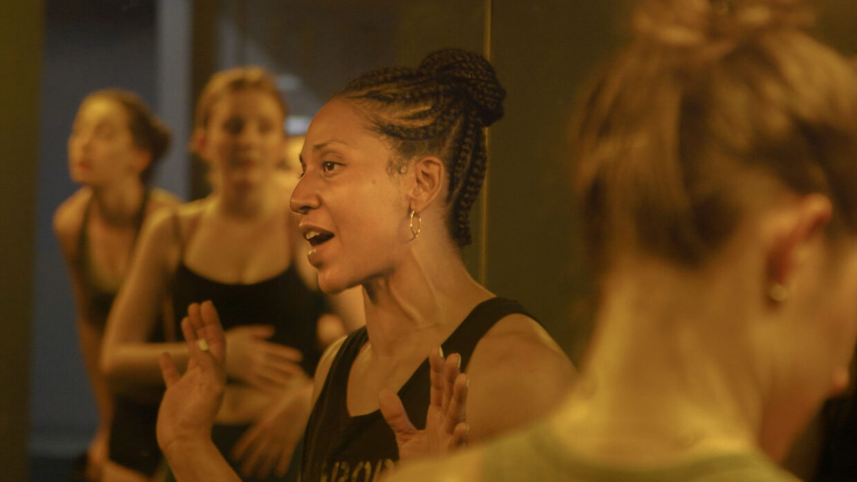 A group of women in fitness clothing are conversing.