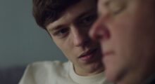 One white man is seen in profile while a younger white man looks at him.