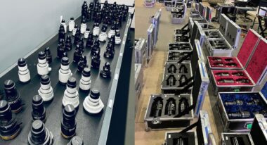 A number of camera lenses laid out on a shelf and in packing cases.