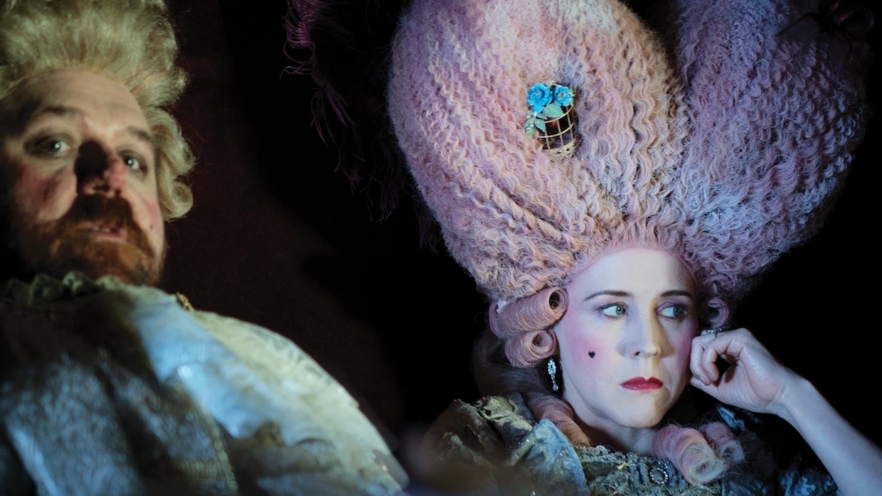 A man and woman in Elizabethan royal costume stare into the distance.