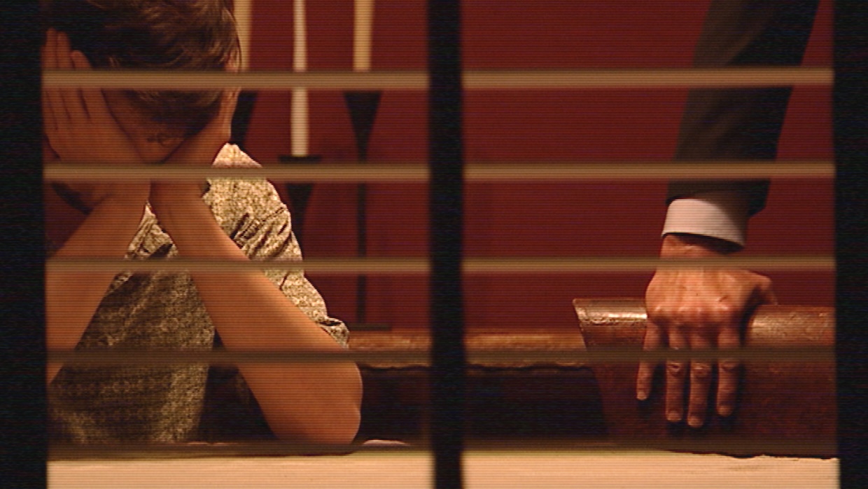 A man holds his head in his hands while seated at a table.