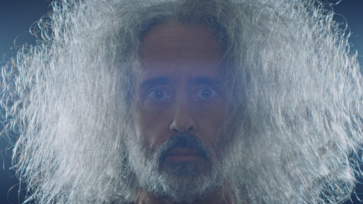 Close-up of a brown-skinned men with long gray hair.