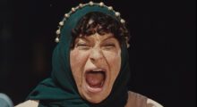 A woman with a green scarf around her head is screaming.