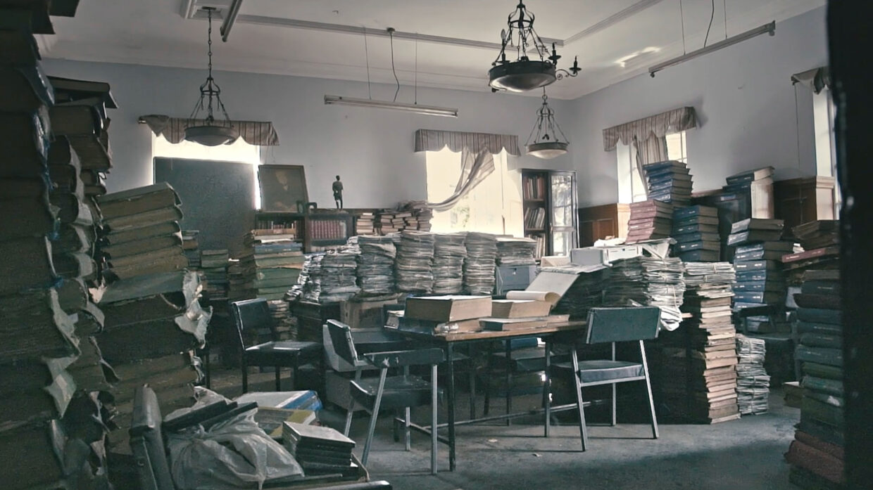 Countless stacks of books are piled up in a room.
