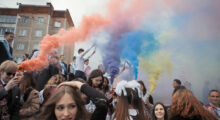 Pride colored smoke at a crowded protest.
