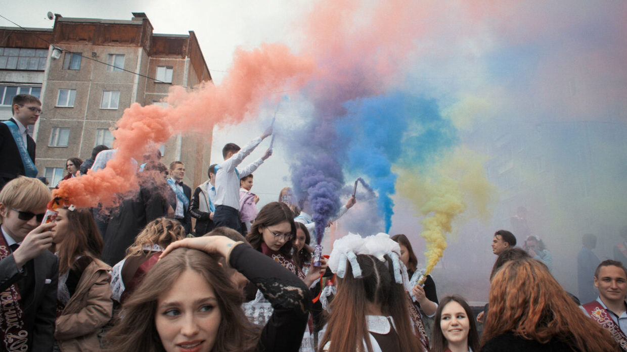 Pride colored smoke at a crowded protest.