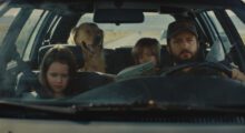 A white man, two white children, and a golden retriever are sitting in a car.