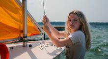 A white woman is sailing.