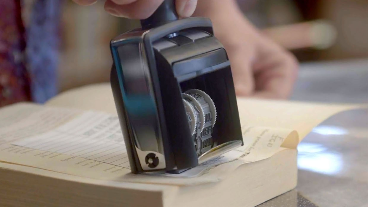 A black stamp marks the return date on a library book.