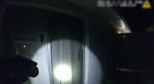 A flashlight is shining onto a wall in an otherwise pitch-black room.