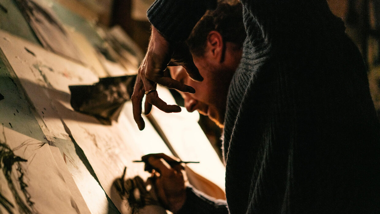 A white man is making sketches.