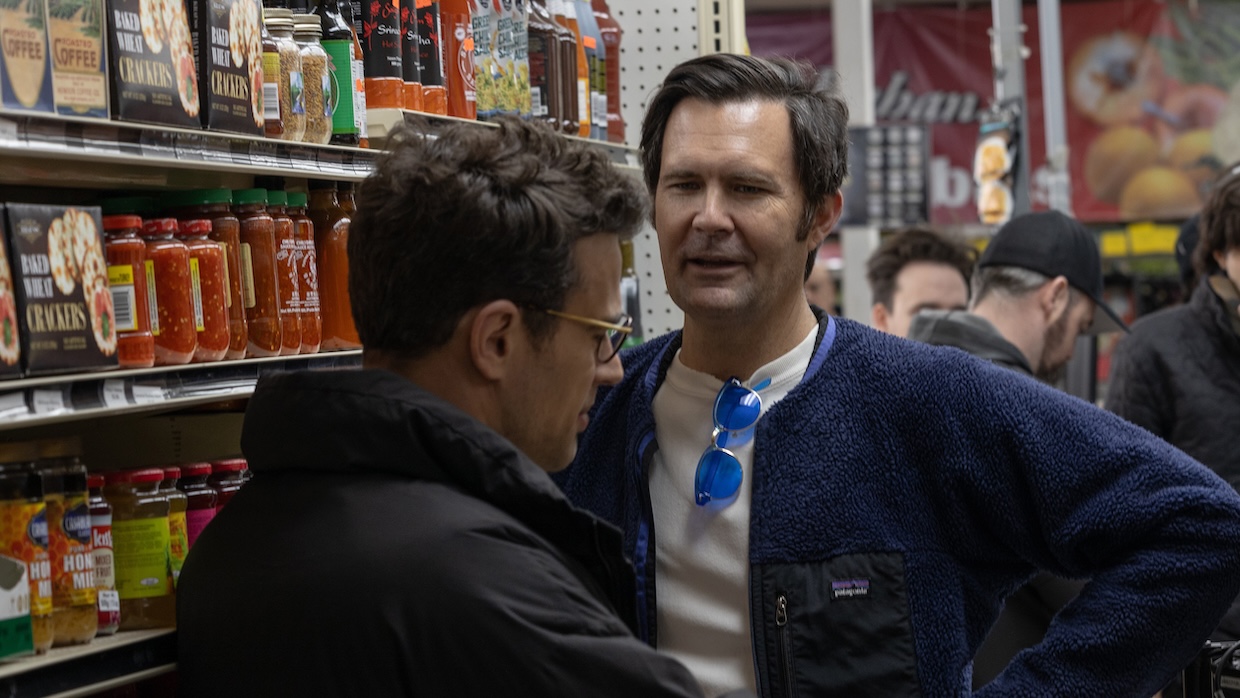 Two men talk to each other in a grocery store.