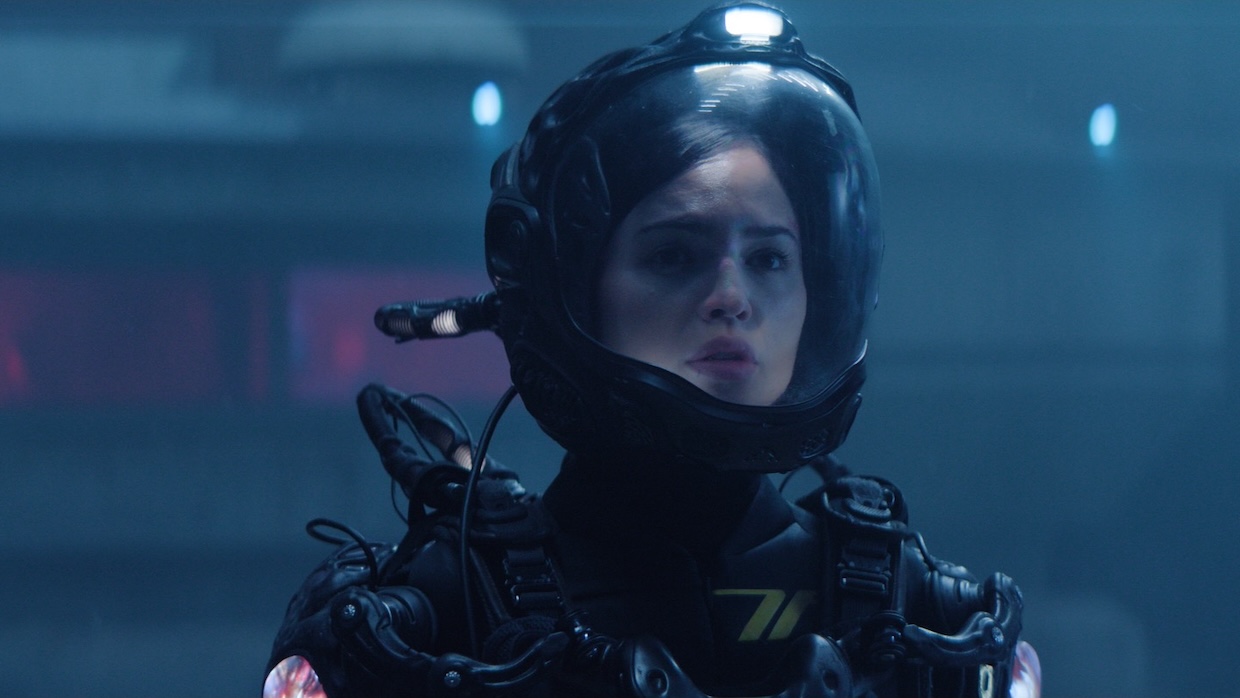 A woman in a spacesuit looks concerned.
