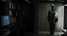 An AI-generated personal assistant on a personal computer screen shares a room with a sinister costume.