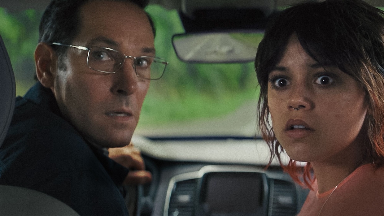 A father and daughter give big looks directly to camera in a car.