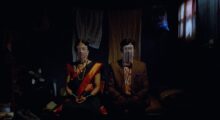 An Indian couple sit in a dark room.