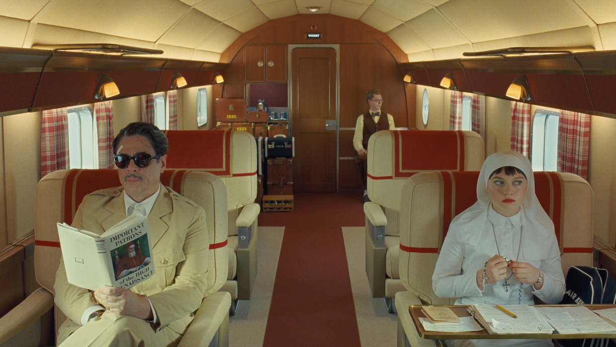 Three people sit on an elaborate, expensive private airplane.