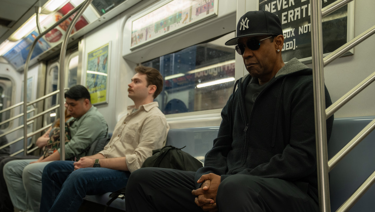 Three men sit in a New York subway car.
