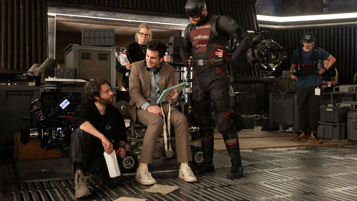 A group of people on a film set, one of whom is in a superhero costume.