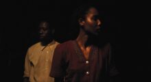A man and a woman in darkness.
