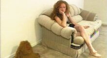 A woman sits on a couch.