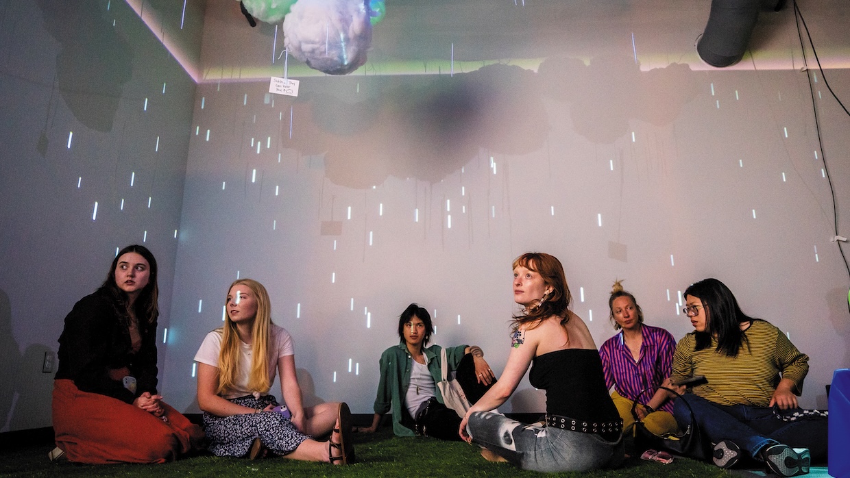 A group of students sit in a multimedia space.