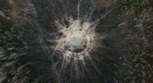 A drone view of a crater caused by warfare.