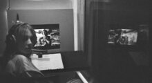 Maya Hawke records voiceover as her own portrayal of a video store clerk looks on.