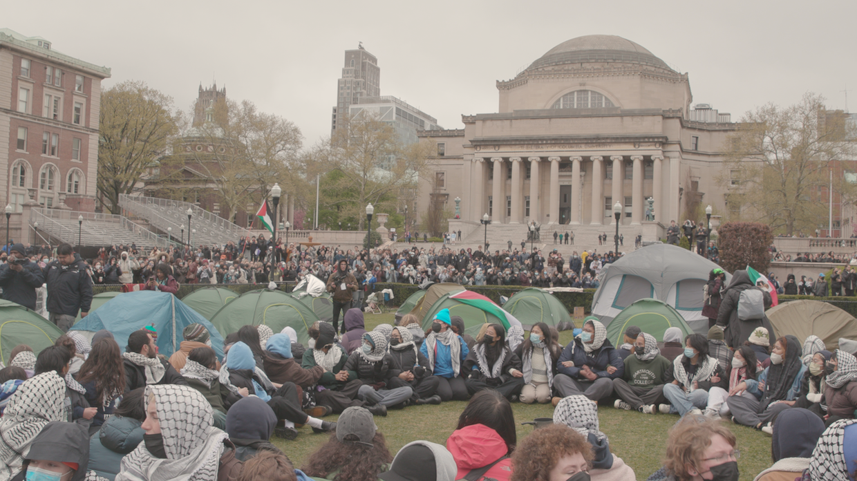 Young people in tents on a lawn.
