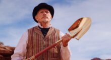A man holds a gold shovel.