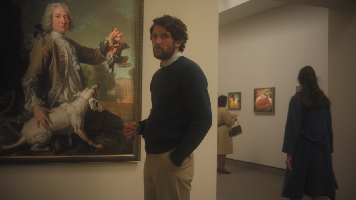 A man stands in front of a painting in a museum.