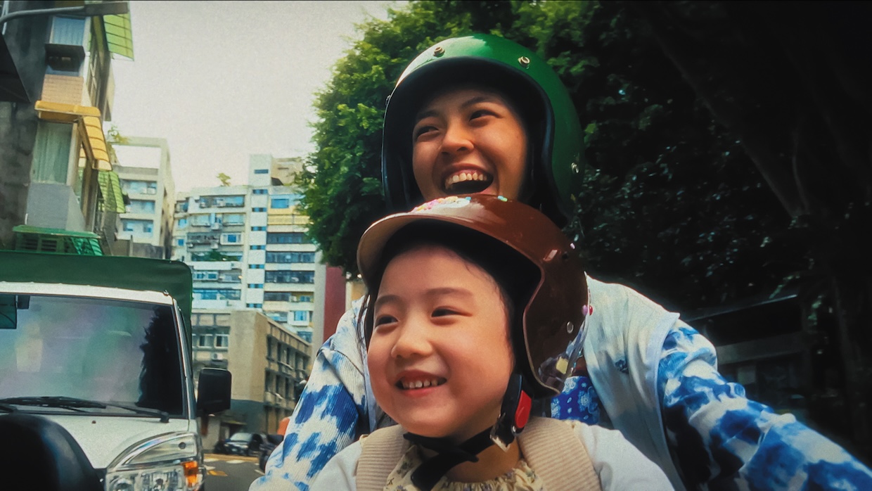 A girl and a woman on a moped.