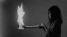 A girl holds a torch on fire