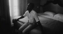 A man sits on a bed.