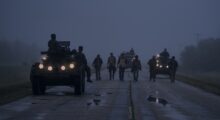 Men take a long walk on a dusky road.