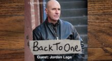 Actor Jordan Lage, who sports a shaved head and black leather jacket.