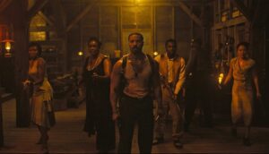 The ensemble cast of Sinners, in character, as they stand sweaty and scared before a battle with vampires.