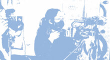 A blue and white image of a woman wearing a face mask and shooting with a digital film camera.