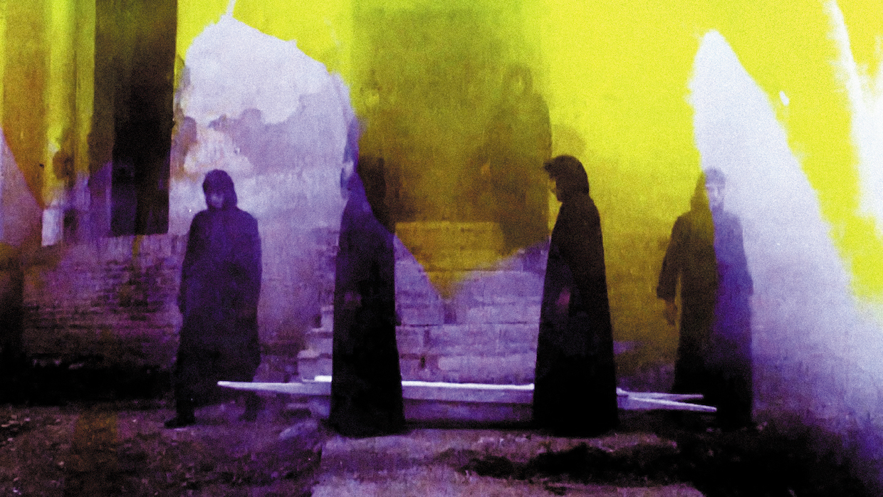 Woman wearing hijabs and long dresses stand in a circle. Their image is colored with a hazy yellow background and hazy purple foreground.