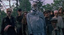 A group of Belarusian villagers and child soldiers circa WWII don filthy military regalia and have even dressed a skeleton in an overcoat.